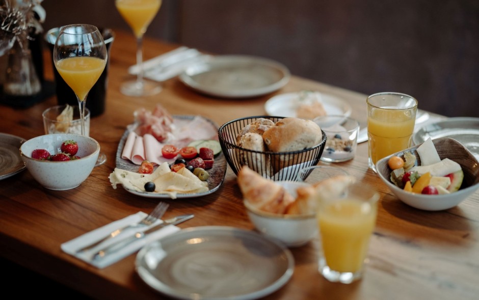 Frühstückstisch mit frischem Gebäck, Obst und Säften im Hotel Resl in Flachau