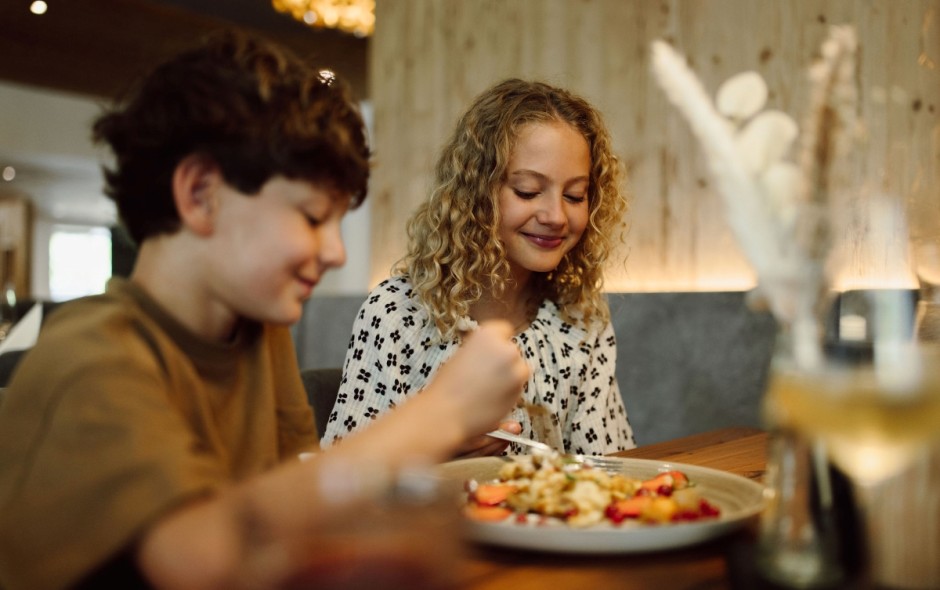 Zwei Kinder genießen das Essen im Restaurant des Hotel Resl