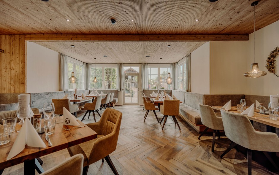 Moderner Speisesaal mit gedeckten Tischen im Resl Resort Flachau