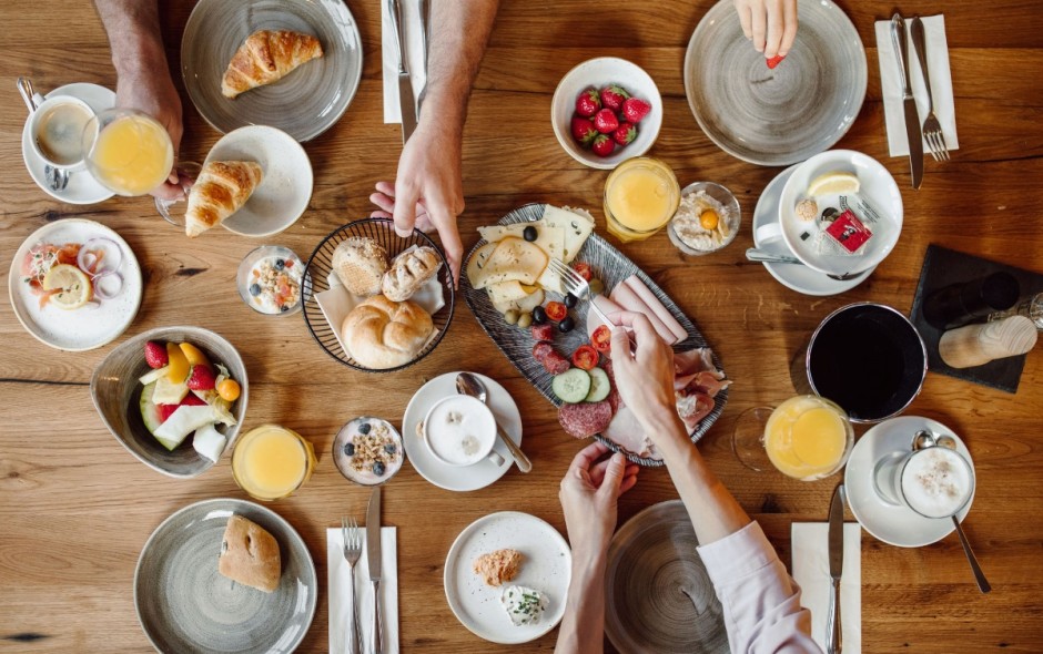 Reich gedeckter Frühstückstisch mit Obst, Gebäck und Säften im Hotel Resl
