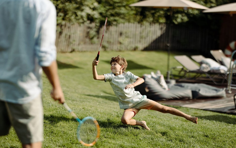 Kinder spielen Badminton auf der Wiese beim Hotel Resl