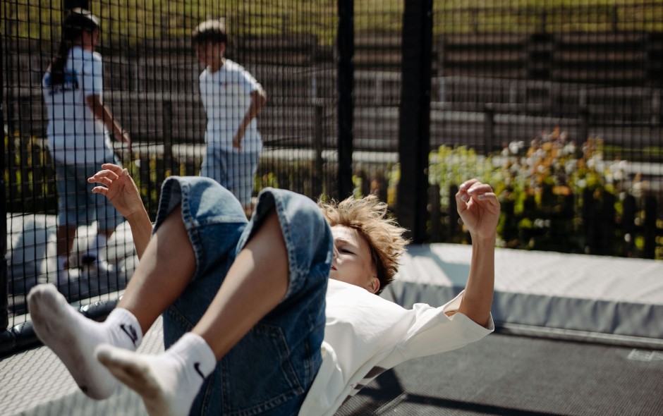 Fröhlich springende Kinder auf einer Outdoor-Trampolinanlage im Hotelgarten in Flachau