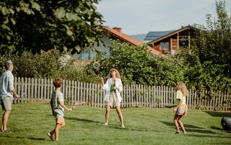 Familie spielt Federball im großen Garten des Resl Resort in Flachau