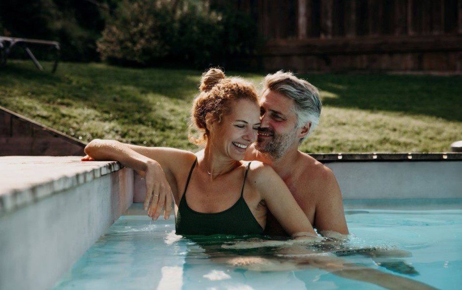Paar lacht gemeinsam im Pool des Hotel Resl Resort in Flachau und genießt den Urlaub