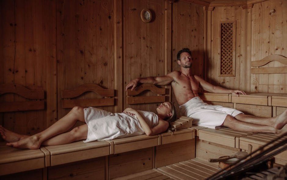 Eine Dame und ein Mann entspannen in der Sauna des Hotel Resl Resort in Flachau und genießen Wellness pur