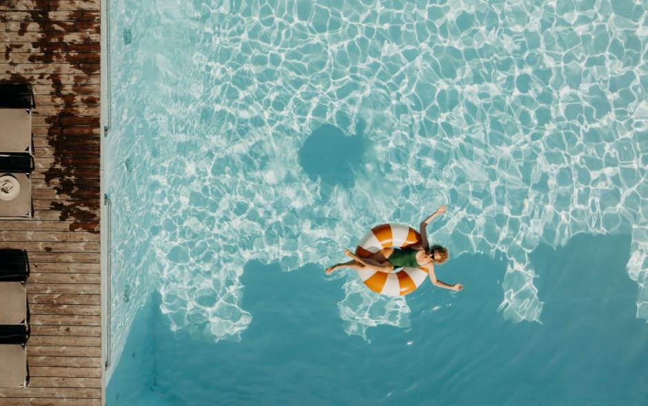 Gast treibt entspannt auf einer Luftmatratze im Pool des Hotel Resl Resort in Flachau