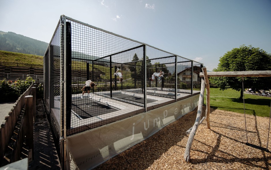 Moderne Outdoor-Trampolinanlage auf dem Spielplatz eines Familienhotels in Flachau mit Natur- und Bergkulisse
