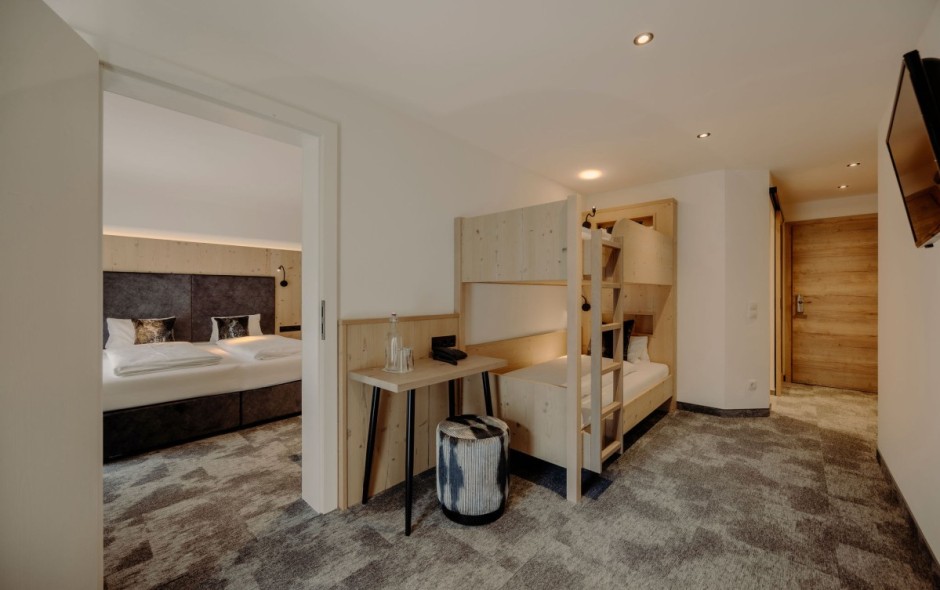 Schlafzimmer mit Doppelbett und Stockbett der Suite Small im Reslresort in Flachau